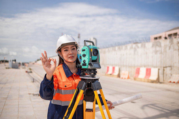 Construction Worker with Surveying Equipment Outdoors