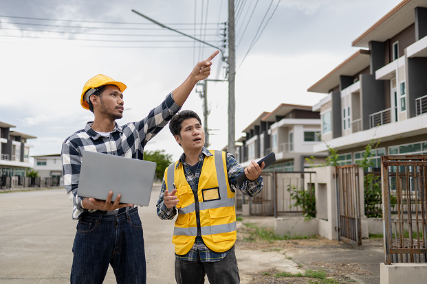 Construction Inspectors Reviewing Property Development with Laptop