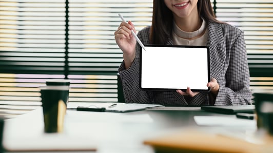 smiling-young-woman-in-business-suit-holding-digit-2022-09-29-18-54-32-utc-min