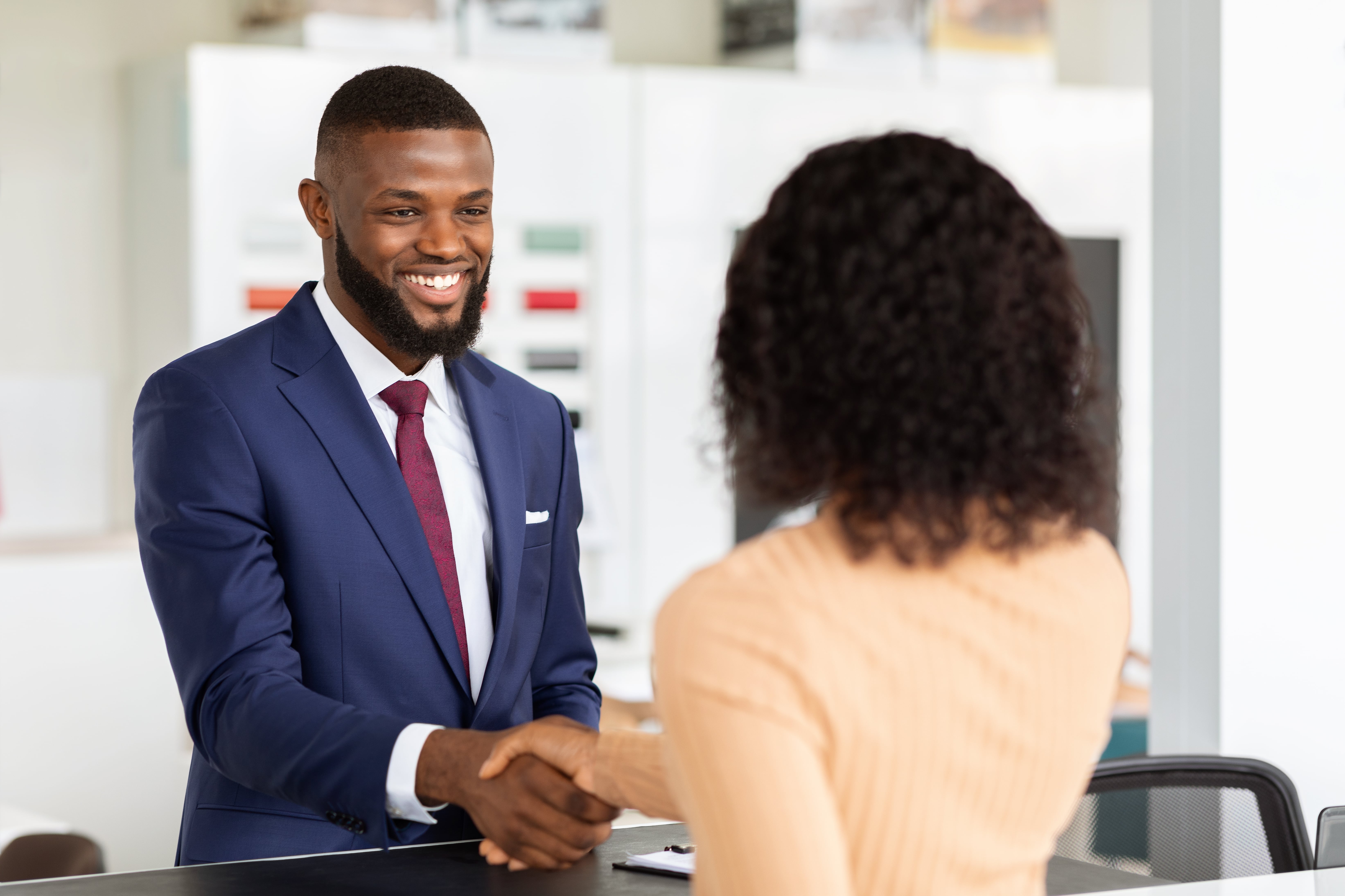 smiling-car-seller-shaking-hands-with-female-custo-2022-10-07-01-24-46-utc-min